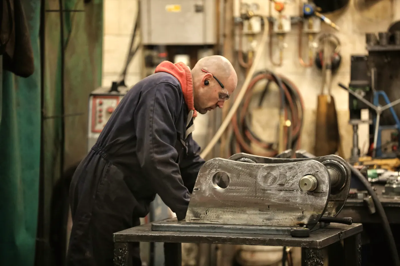 An engineer works on a machine part in a workshop.